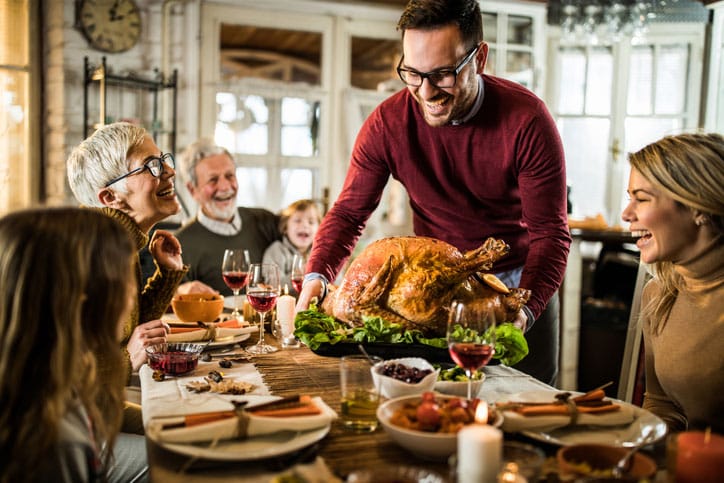 Man Serving Thanksgiving Turkey to Family